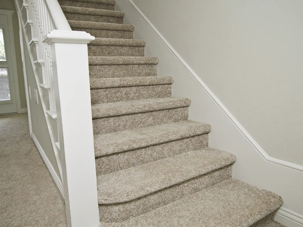 Carpeted staircase with individually fitted treads and risers